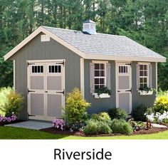 a small gray shed sitting in the grass