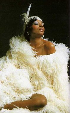 a woman sitting on the ground in white feathers