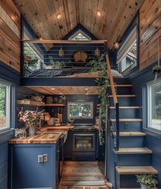 the interior of a tiny house with stairs leading up to the loft and kitchen area