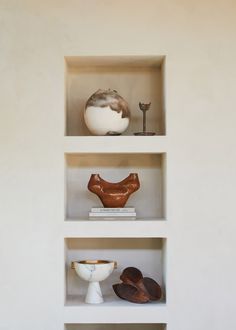 three shelves filled with different types of vases and other items on top of each shelf