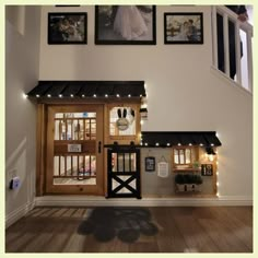 there is a doll house with pictures on the wall and lights in front of it