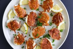 a white plate topped with crab cakes and lemon wedges