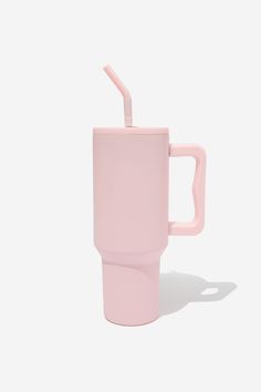 a pink coffee cup with a straw sticking out of it's side, against a white background