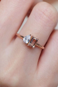 a woman's hand with a diamond ring on top of her finger and an engagement band