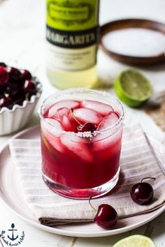 a drink with cherries in it on a plate