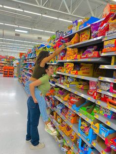 a woman is leaning on the shelves in a grocery store