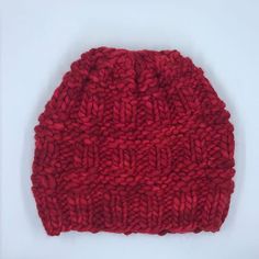 a red knitted hat sitting on top of a white table