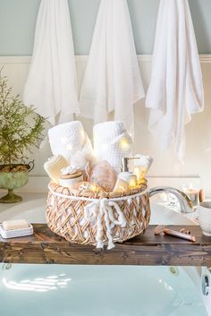 a basket filled with lots of white towels next to a tub full of soaps