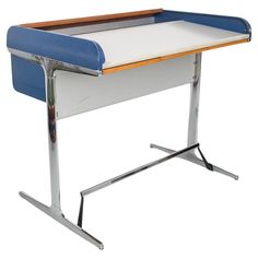 a blue and white desk sitting on top of a metal stand with a wooden edge