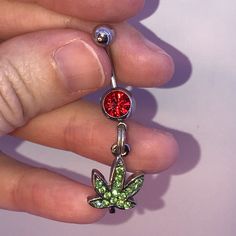 These Are 316-L Stainless Steel Belly Ring With A Dangle Of A Pot Leaf Design. The Ring In The Middle Is A Split Or Spring Ring. It's Designed This Way So Your Charm Stays On Your Belly Ring. Green Rhinestone Leaf With Red Top Silver Split Ring If You Want A Different Color Belly Ring Let Me Know I Can Change Them Out. This Is A Standard 14 Gauge Belly Ring. The Top Gem Changes From One Belly Ring To Another But The Bottom Stays The Same. It Is A Peridot Green Rhinestone Pot Leaf That Is Made Ou Cute Belly Rings Stud, Cool Belly Rings, Red Jeweled Metal Jewelry, Red Metal Jewelry With Rhinestones, Adjustable Red Stone Jewelry, Adjustable Red Jewelry With Stones, Adjustable Red Jeweled Jewelry, Red Metal Body Jewelry For Gift, Red Metal Body Jewelry As A Gift