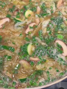 broccoli and mushrooms are being cooked in a pot