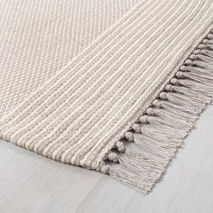 a white rug with fringes on the floor