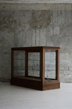 an empty display case sitting in front of a brick wall with no people around it