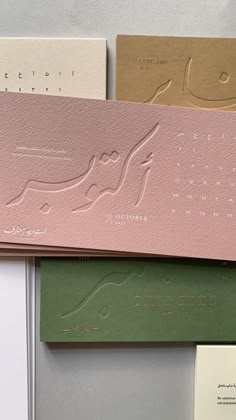 three different types of business cards on top of each other, one in pink and the other in green