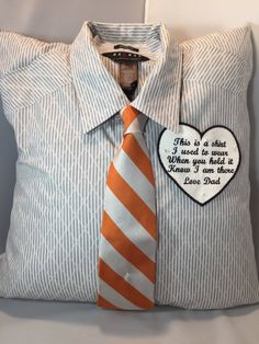 an orange and white striped neck tie on a pillow with a message written on it