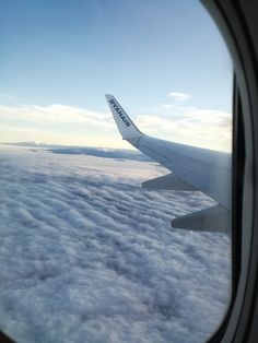 the wing of an airplane flying above clouds