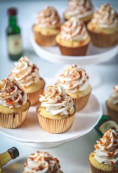 several cupcakes with white frosting and orange sprinkles on plates