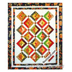 a quilted wall hanging with an orange, green and red design on the front