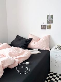 a black and white checkered floor in a bedroom with pink sheets on the bed