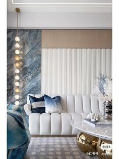 a living room filled with white furniture and blue pillows on top of a couch next to a