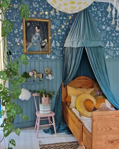 a child's bedroom decorated in blue and pink with a canopy over the bed