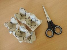 a pair of scissors sitting on top of a wooden table next to an egg shell