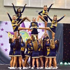 a group of cheerleaders standing on top of each other in front of a stage