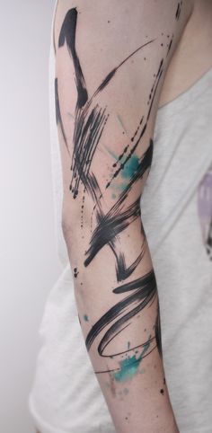 a woman's arm with black and blue paint splattered on it,