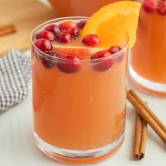 two glasses filled with orange juice and garnished with pomegranates