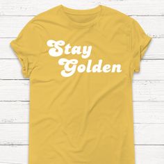 Features: * 100% Ringspun Cotton * Weight: 5 Oz. * Seamless Rib At Neck * Taped Shoulder-To-Shoulder * Double-Needle Stitching Throughout Gold Shirt, The Golden Girls, Stay Golden, Gold Vinyl, Golden Girls, Book Decor, Game Changer, Tshirt Colors, The Golden