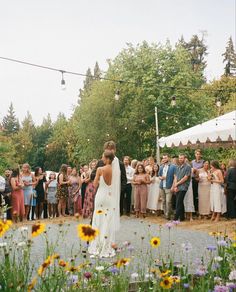 a bride and groom are standing in front of a group of people at a wedding