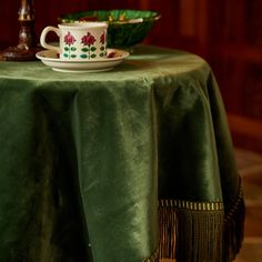 a green table cloth with a cup and saucer on it