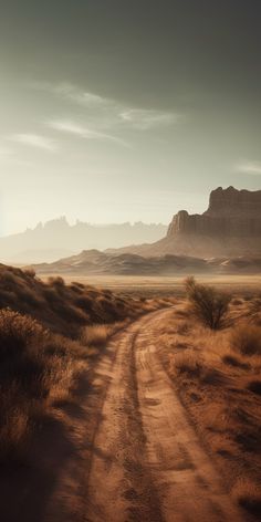 an empty dirt road in the middle of desert with mountains in the backgroud