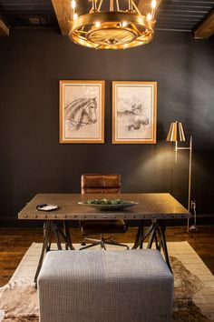 a dining room table with two pictures on the wall