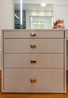 a dresser with drawers and a mirror in the background