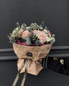 a person holding a bouquet of flowers in their hand on the side of a building