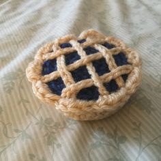 a crocheted basket sitting on top of a bed