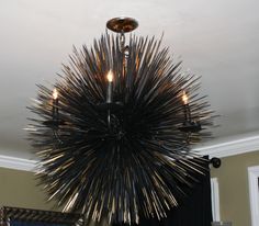 a black chandelier hanging from the ceiling in a room with beige walls and white trim