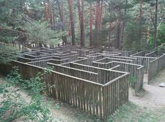 a wooden structure in the woods surrounded by trees