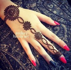 a woman's hand with henna tattoos on it