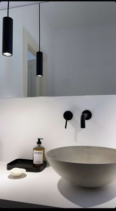 a bathroom with a sink, mirror and soap dispenser on the counter