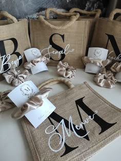 burlap bags with monogrammed names and bows are sitting on a table