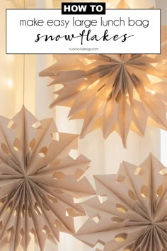 paper snowflakes hanging from the ceiling with text overlay reading how to make easy large lunch bag snowflakes