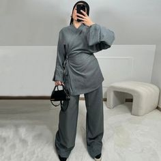 Step into effortless elegance with the Kyra Belted Kimono Style Co-ord Pant Set, a versatile and contemporary outfit that combines comfort and style in perfect harmony. This set features a wrap-style kimono top and wide-leg pants, crafted to offer a sleek and sophisticated silhouette that flatters all body types.The top showcases a modern kimono design with wide, flowing sleeves and a side-tie belt that allows you to adjust the fit to your preference. Its minimalist wrap-front design adds a touch of chic simplicity, making it a perfect piece for both casual and more polished looks.The coordinating pants feature a high-waisted, wide-leg cut that creates a long, lean line, enhancing your overall look with an air of elegance. The pants offer ease of movement and comfort, perfect for day-to-ni Wrap Trousers Outfit, Kimono Top Outfit, Kimono With Pants, Esthetician Outfit, Kimono Set, Belt Kimono, Flowing Sleeves, Modern Kimono, Kimono Outfit