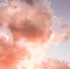 an airplane is flying in the sky with pink and blue clouds behind it at sunset