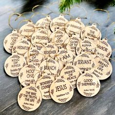 wooden ornament with the names of jesus and his name on it, surrounded by pine branches