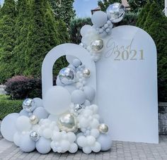 a large balloon arch with silver and white balloons