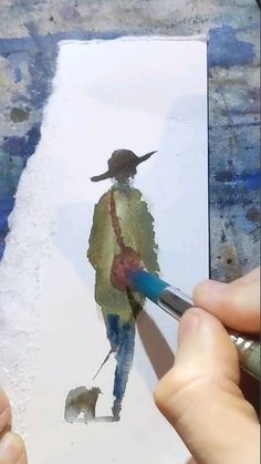 a person is painting with watercolors on paper