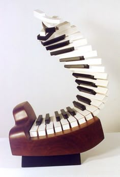 a sculpture made out of piano keys on a wooden stand