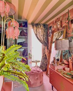 a room with pink furniture and lots of pictures on the wall, including a large mirror